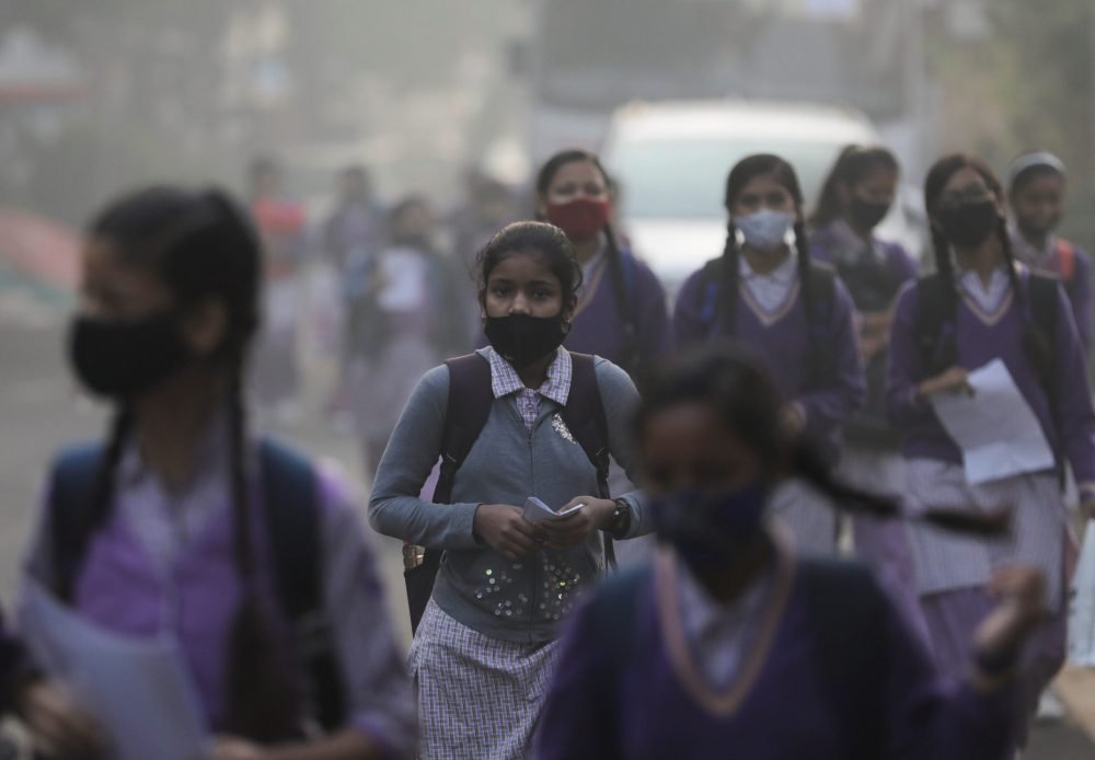 FILE PHOTO: School girls walk towards a school as they reopened after remaining closed for nearly 15 days due to a spike in air pollution, on a smoggy morning in New Delhi, India, November 29, 2021. REUTERS/Anushree Fadnavis