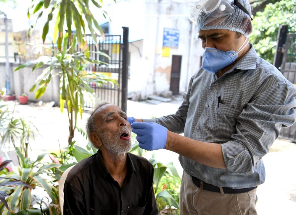 New Delhi, Mar 31 (ANI): A healthcare worker collects a swab sample of a man for the COVID-19 testing amid a spike in Coronavirus cases, in New Delhi on Friday. (ANI Photo)