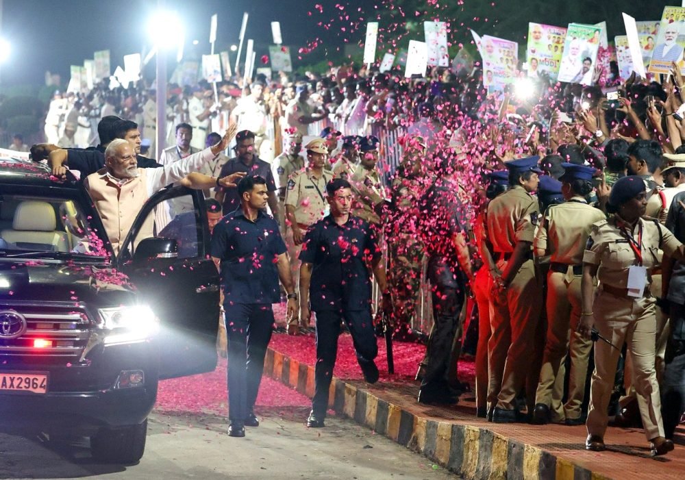 Tirupati, Nov 26 (ANI): Prime Minister Narendra Modi being showered with flower petals during a roadshow on his arrival in Tirupati on Sunday. (ANI Photo)
