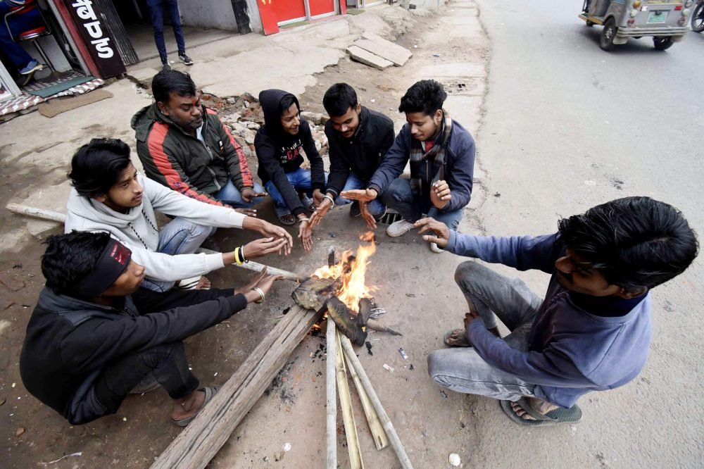 Patna, Dec 30 (ANI): People sit around a bonfire to warm themselves on a cold winter day, in Patna on Saturday. (ANI Photo)